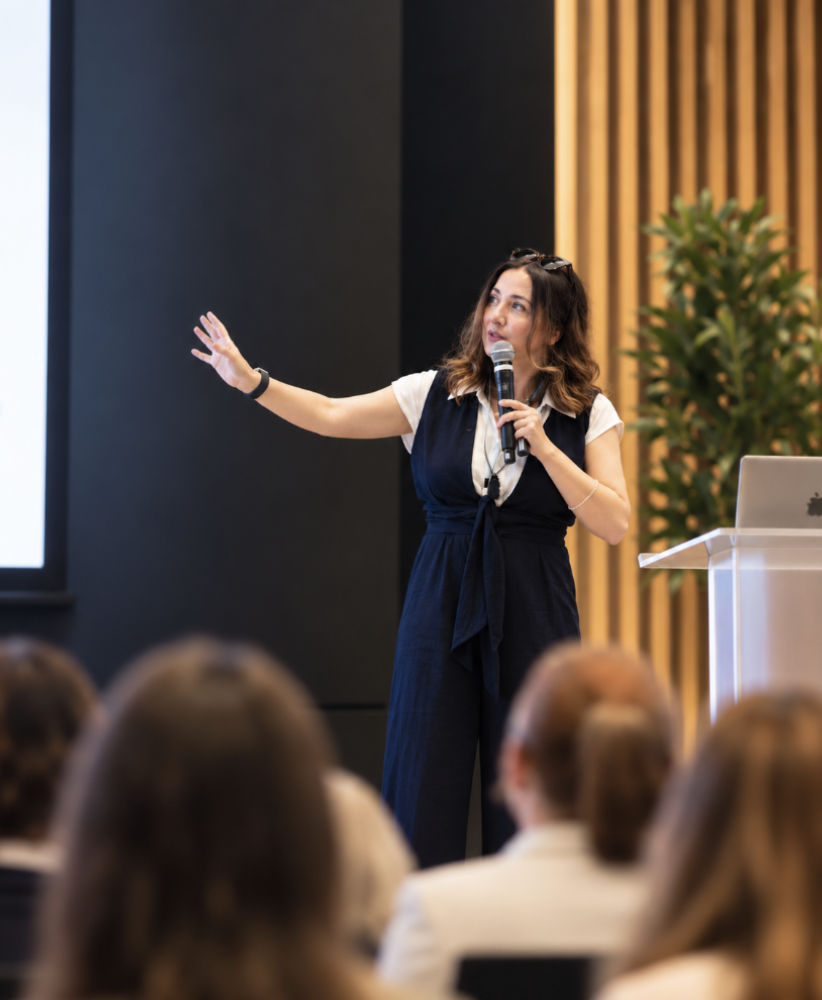 Tina Austin speaking to an audience at a conference